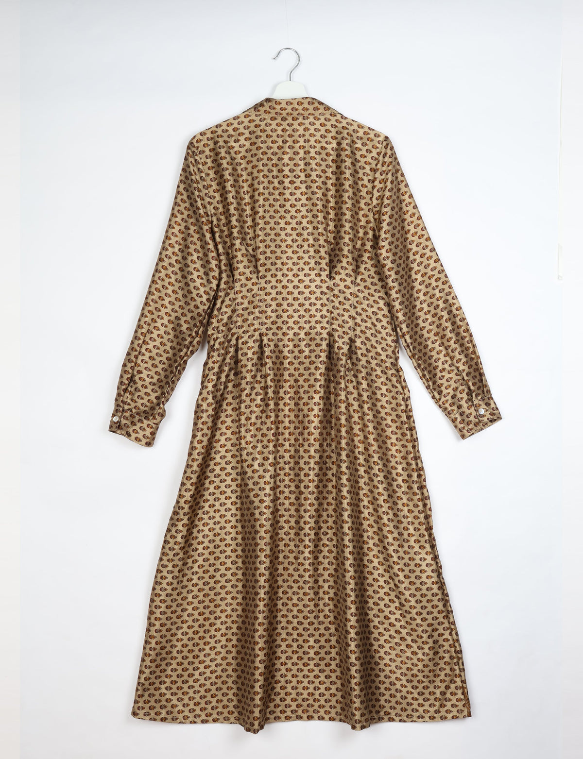 Beige midi shirt dress with long sleeves and brown micro pattern, shown from back on white hanger against white background