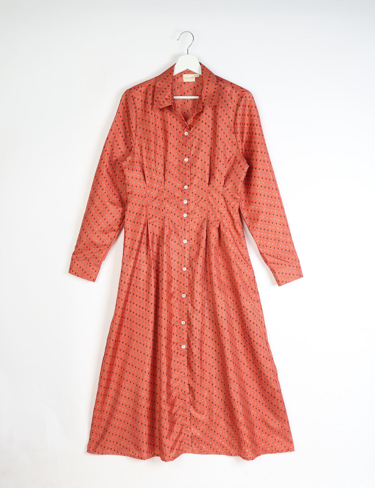 Orange midi shirt dress with micro floral pattern, long sleeves, button front, and collar, hanging on white hanger