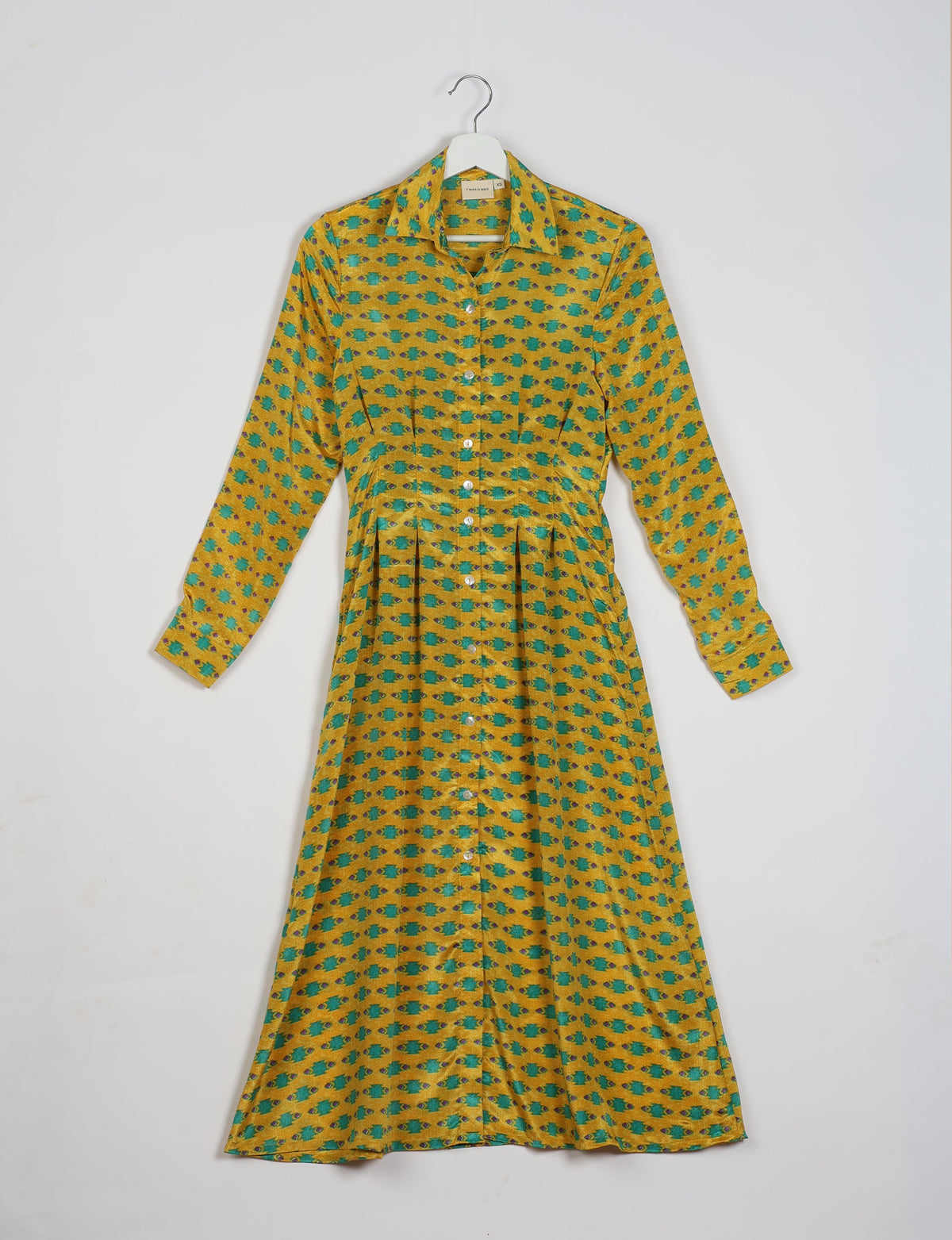 Yellow midi shirt dress with green and purple micro pattern, long sleeves, button front, and collar, hanging on white hanger