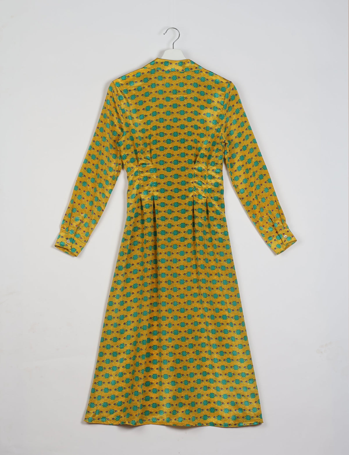 Yellow midi shirt dress with long sleeves, green and brown micro geometric pattern, shown from back on hanger