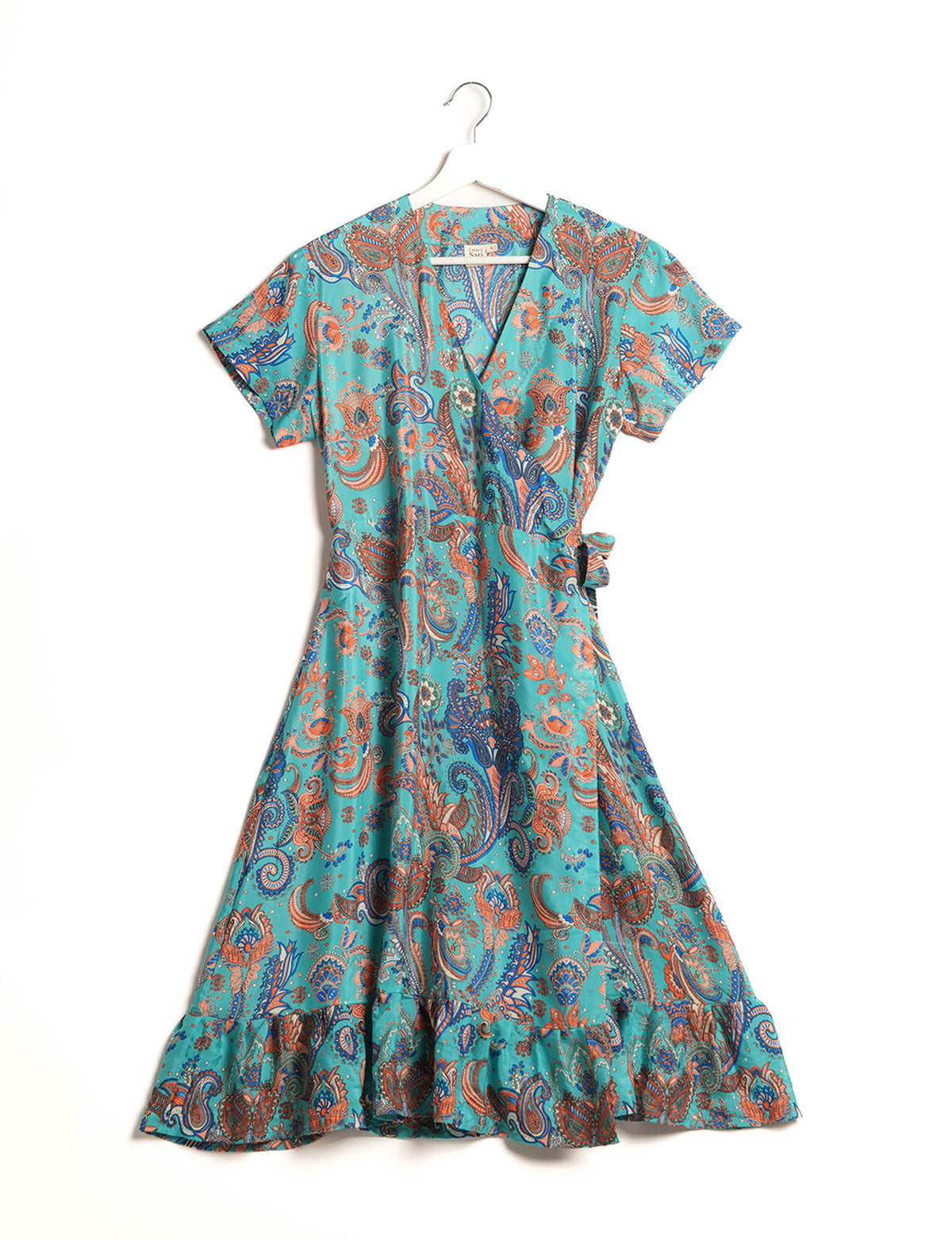 Embrace timeless elegance with our MIDI WRAP DRESS – a midi-length beauty featuring a v-neck, flattery from all angles, and a charming sari belt. Crafted from sustainable materials, this dress embodies ethical clothing and green fashion. Sophisticated with a frill tier at the hem and short cap sleeves, this dress is perfect for any occasion. Tie up the beautifully crafted sari belt on the side for a versatile, stylish, and eco-friendly look.