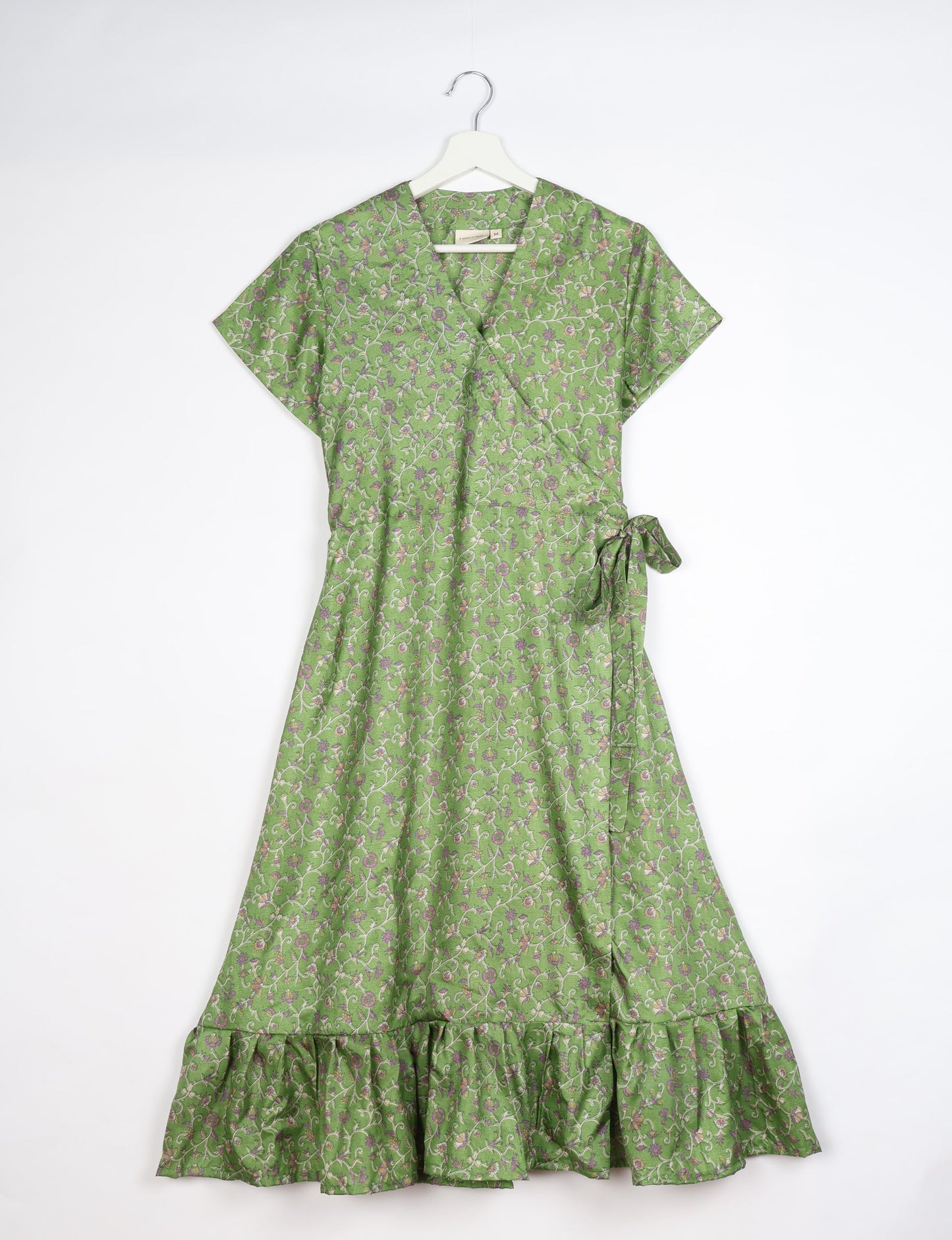 Embrace timeless elegance with our MIDI WRAP DRESS – a midi-length beauty featuring a v-neck, flattery from all angles, and a charming sari belt. Crafted from sustainable materials, this dress embodies ethical clothing and green fashion. Sophisticated with a frill tier at the hem and short cap sleeves, this dress is perfect for any occasion. Tie up the beautifully crafted sari belt on the side for a versatile, stylish, and eco-friendly look.