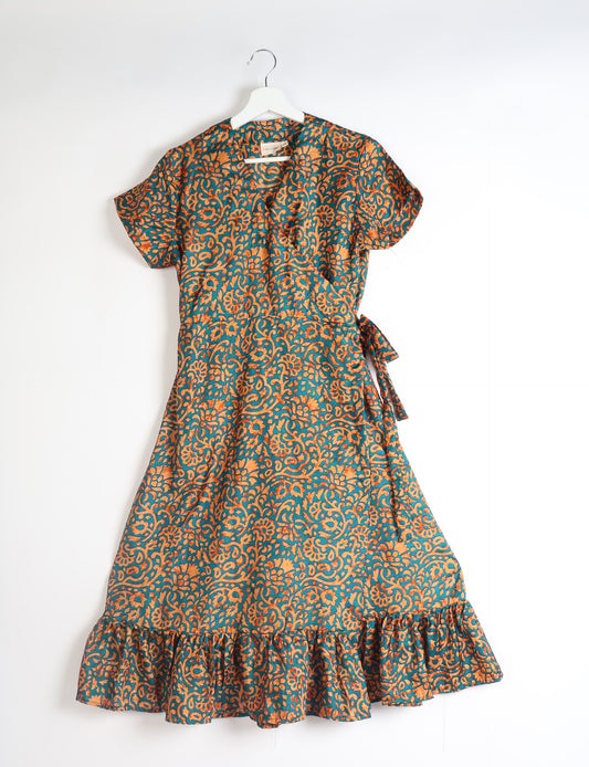 Embrace timeless elegance with our MIDI WRAP DRESS – a midi-length beauty featuring a v-neck, flattery from all angles, and a charming sari belt. Crafted from sustainable materials, this dress embodies ethical clothing and green fashion. Sophisticated with a frill tier at the hem and short cap sleeves, this dress is perfect for any occasion. Tie up the beautifully crafted sari belt on the side for a versatile, stylish, and eco-friendly look.