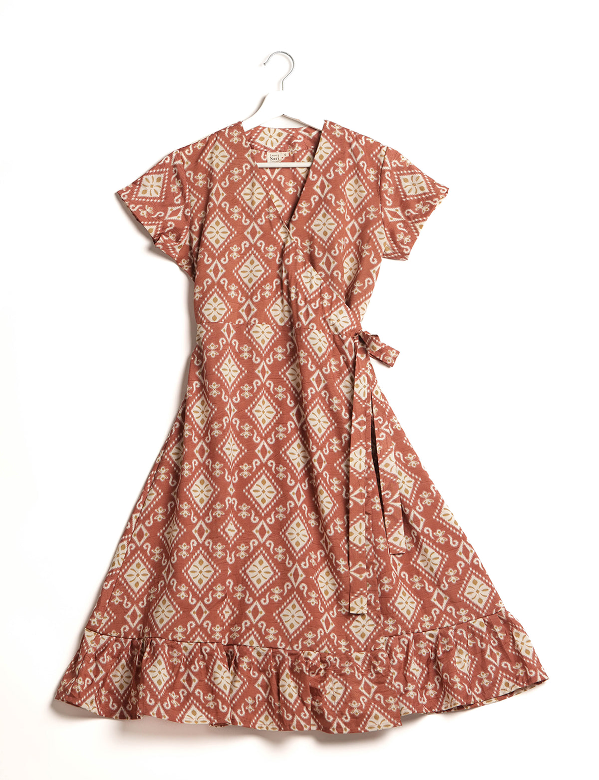 Embrace timeless elegance with our MIDI WRAP DRESS – a midi-length beauty featuring a v-neck, flattery from all angles, and a charming sari belt. Crafted from sustainable materials, this dress embodies ethical clothing and green fashion. Sophisticated with a frill tier at the hem and short cap sleeves, this dress is perfect for any occasion. Tie up the beautifully crafted sari belt on the side for a versatile, stylish, and eco-friendly look.
