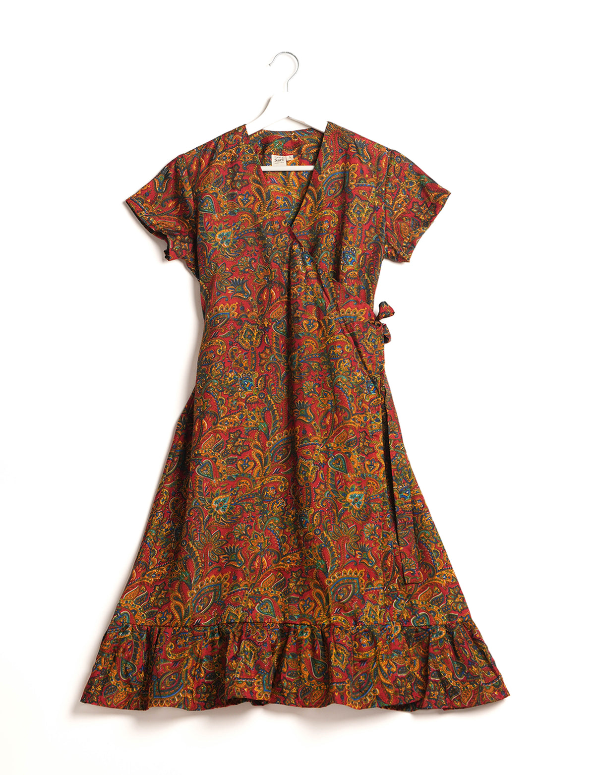 Embrace timeless elegance with our MIDI WRAP DRESS – a midi-length beauty featuring a v-neck, flattery from all angles, and a charming sari belt. Crafted from sustainable materials, this dress embodies ethical clothing and green fashion. Sophisticated with a frill tier at the hem and short cap sleeves, this dress is perfect for any occasion. Tie up the beautifully crafted sari belt on the side for a versatile, stylish, and eco-friendly look.