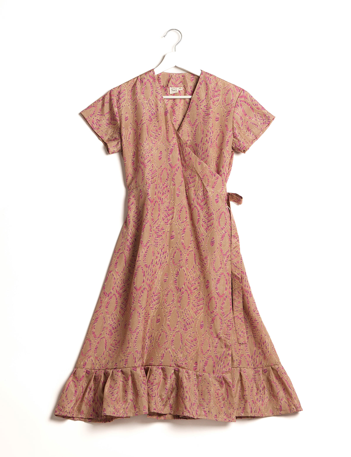 Beige wrap dress with pink leaf pattern, short sleeves, ruffled hem, and side tie, hanging on white hanger front view