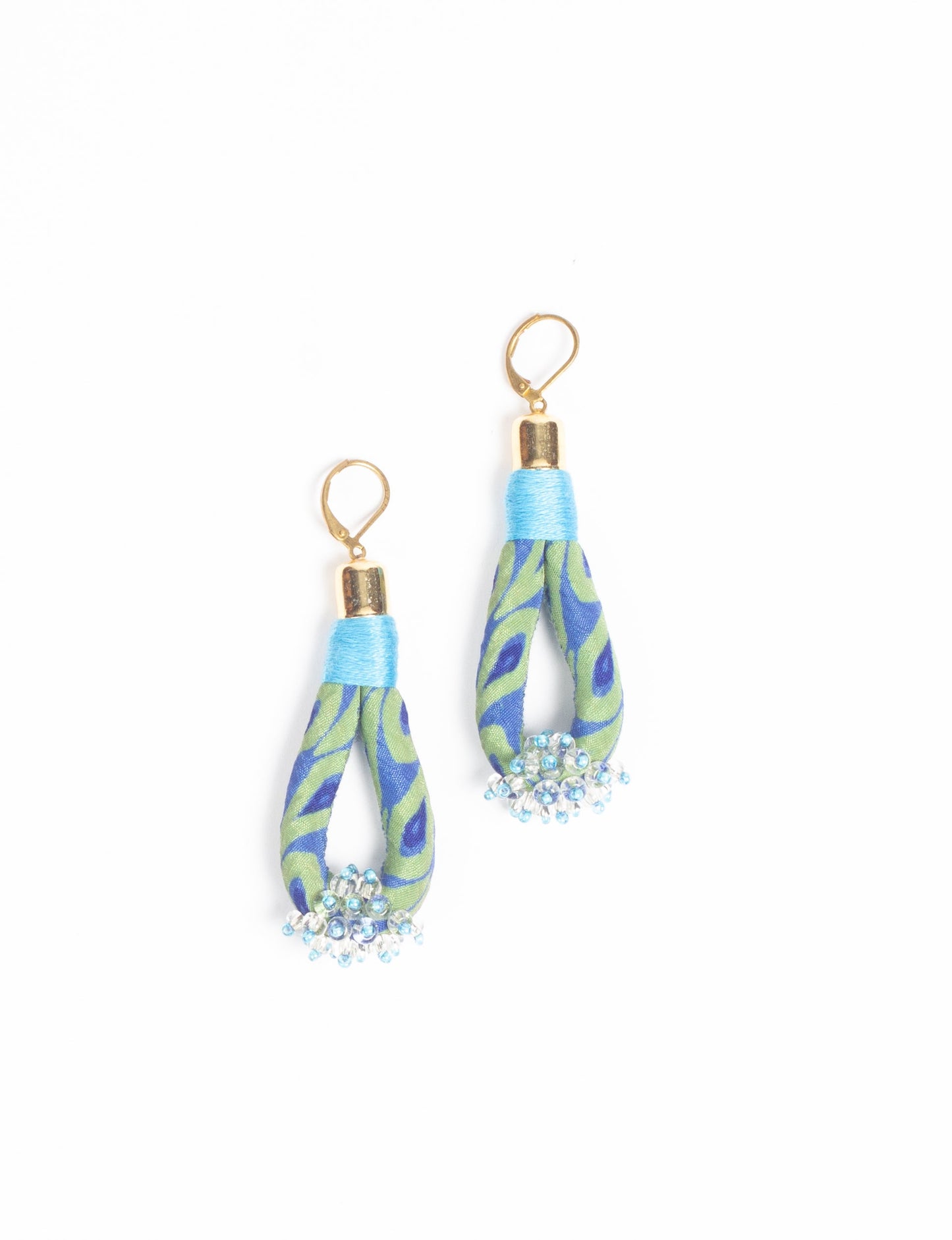 Discover the charm of Beaded Drop Earrings, meticulously crafted by Indian artisans. Recycled cotton rope, sari fabric, and surplus glass beads create an eco-friendly masterpiece. Hypoallergenic metal hooks ensure both style and comfort.