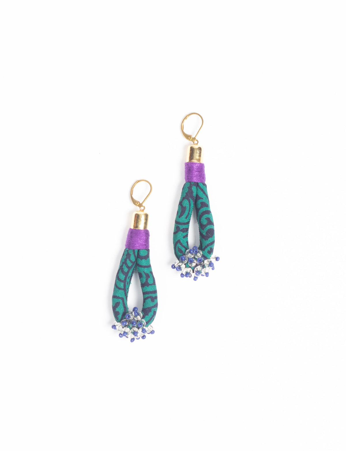 Green and black patterned fabric loop drop earrings with purple thread wrap, gold hooks, and blue and clear bead clusters at ends