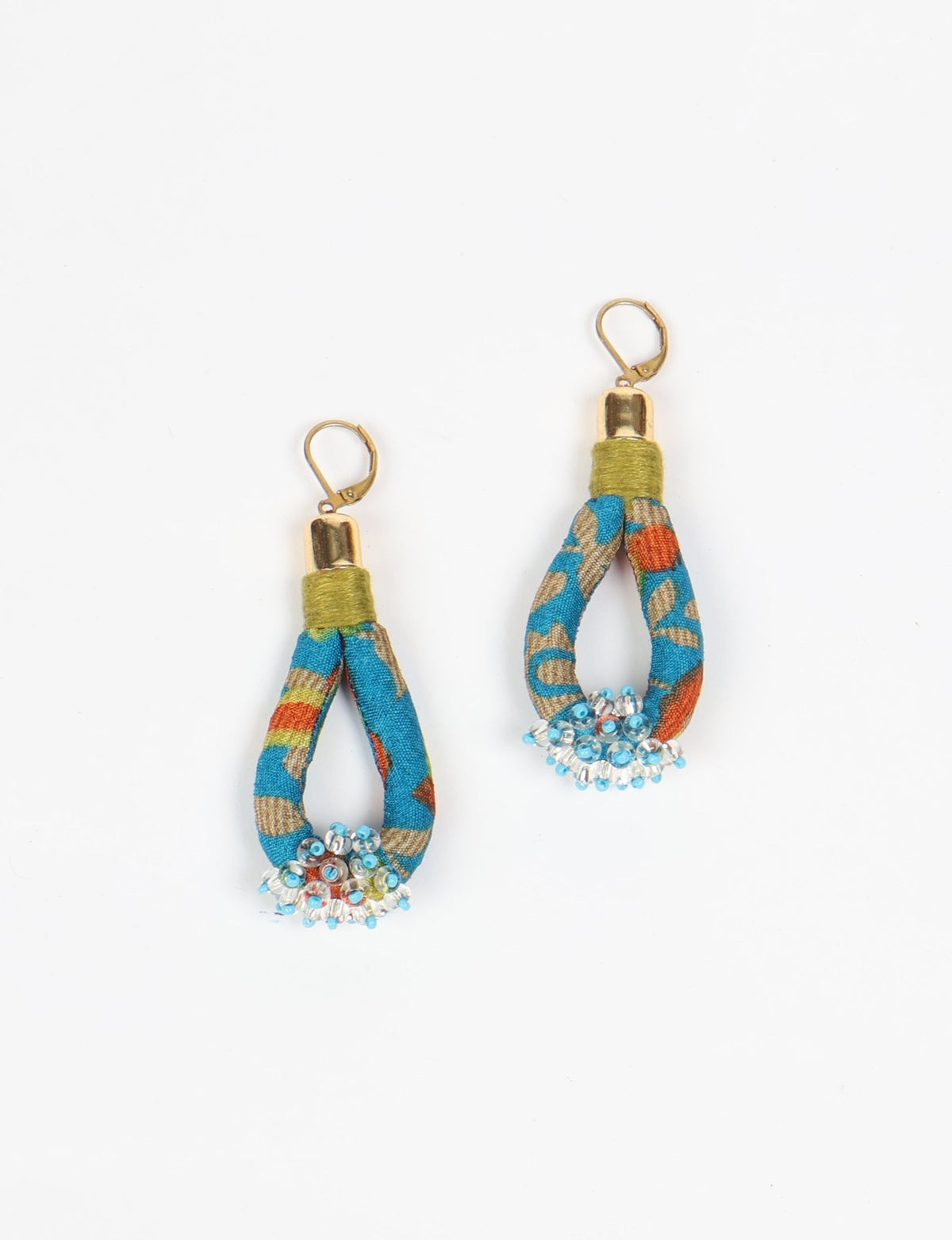 Blue tropical patterned fabric drop earrings with gold-tone hooks and clustered blue and clear beads at the bottom