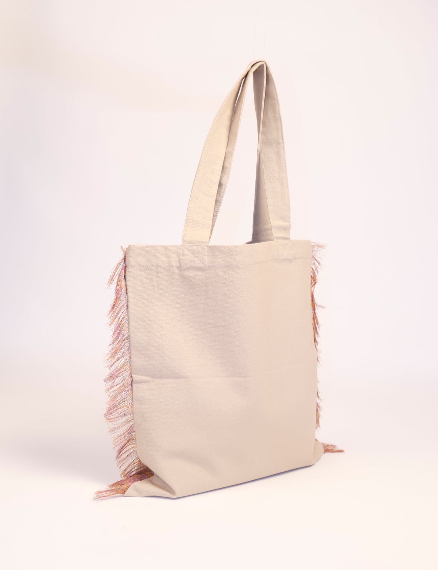 Stylish FRINGE SHOPPER BAG crafted from 100% cotton canvas with sari fringe edging. A spacious and functional accessory, perfect for sustainable shopping with form and fashion in mind.