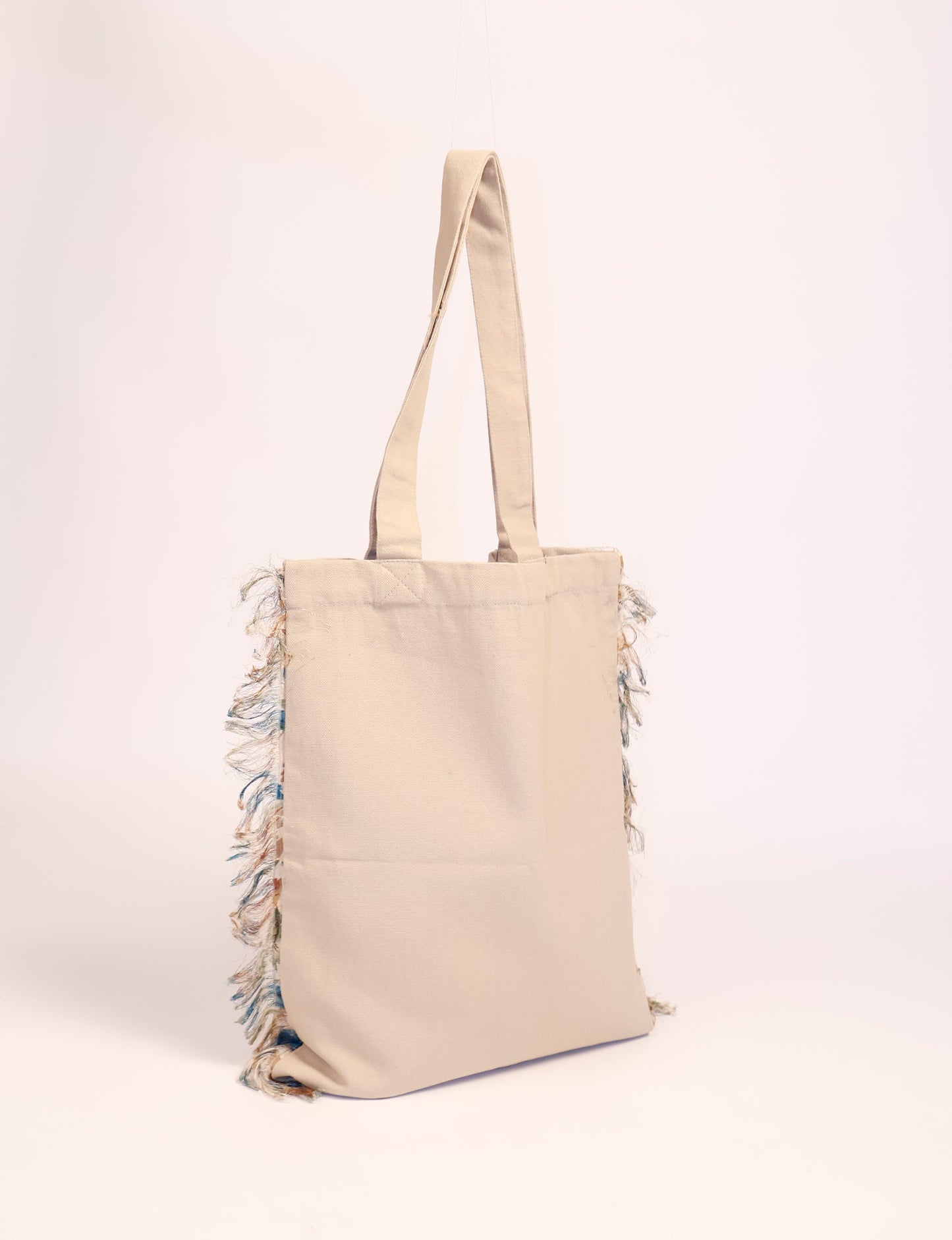 Stylish FRINGE SHOPPER BAG crafted from 100% cotton canvas with sari fringe edging. A spacious and functional accessory, perfect for sustainable shopping with form and fashion in mind.