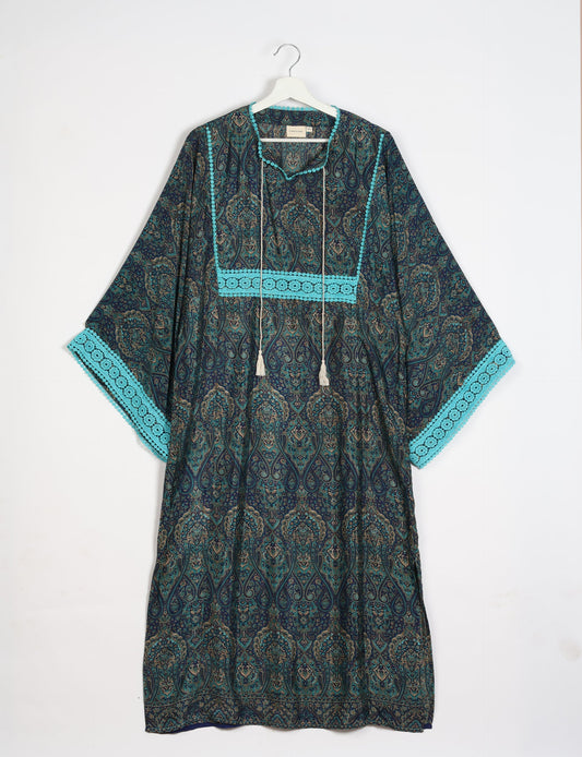 Maxi Kaftan with cotton lace on sleeves and midriff, featuring a tie-up neckline with tassels. Ankle-length, eco-friendly fashion made from recycled materials, offering sustainable women’s clothing for a chic, earth-friendly wardrobe.