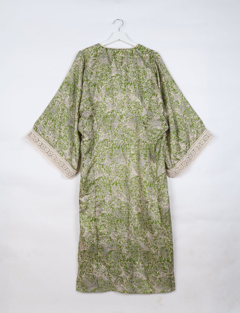 Green tropical maxi kaftan with beige and gray leaf patterns, lace trim on wide sleeves, shown hanging from white hanger
