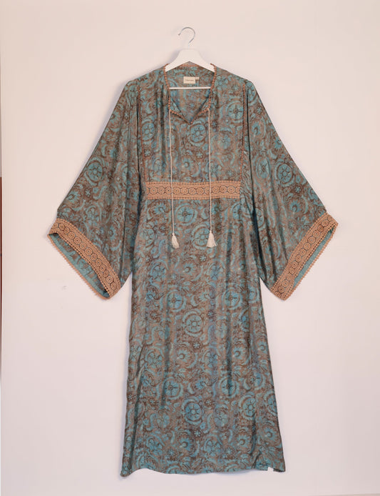 Maxi Kaftan with cotton lace on sleeves and midriff, featuring a tie-up neckline with tassels. Ankle-length, eco-friendly fashion made from recycled materials, offering sustainable women’s clothing for a chic, earth-friendly wardrobe.