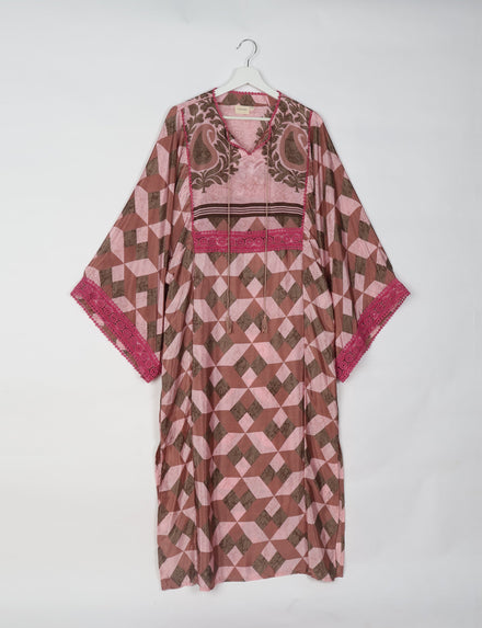 Brown and pink geometric patterned maxi kaftan with V-neck, tassel ties, and pink lace trim on sleeves, hanging on white hanger