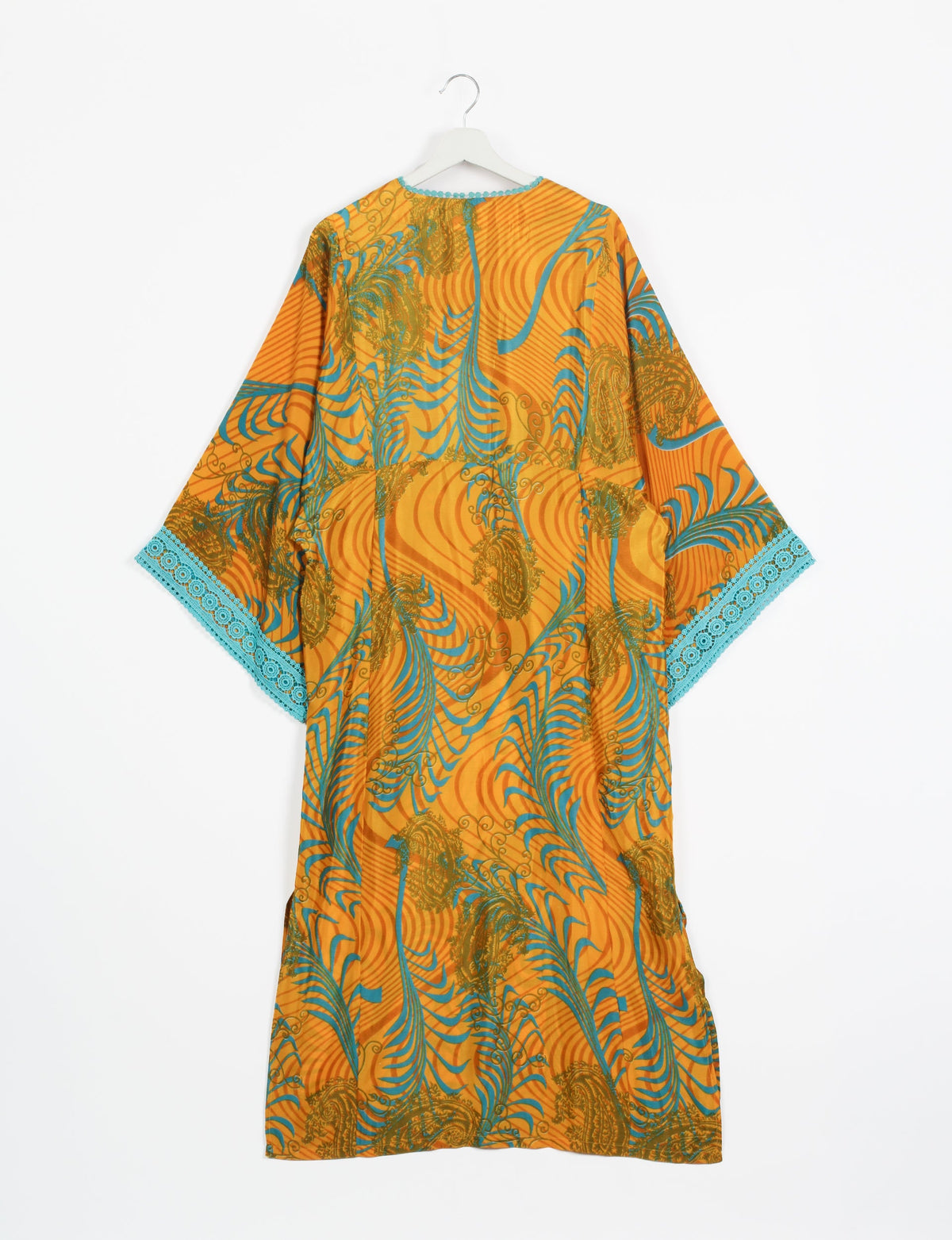 Maxi kaftan in yellow with abstract blue and brown swirls, turquoise lace trim on sleeves, shown from back on hanger