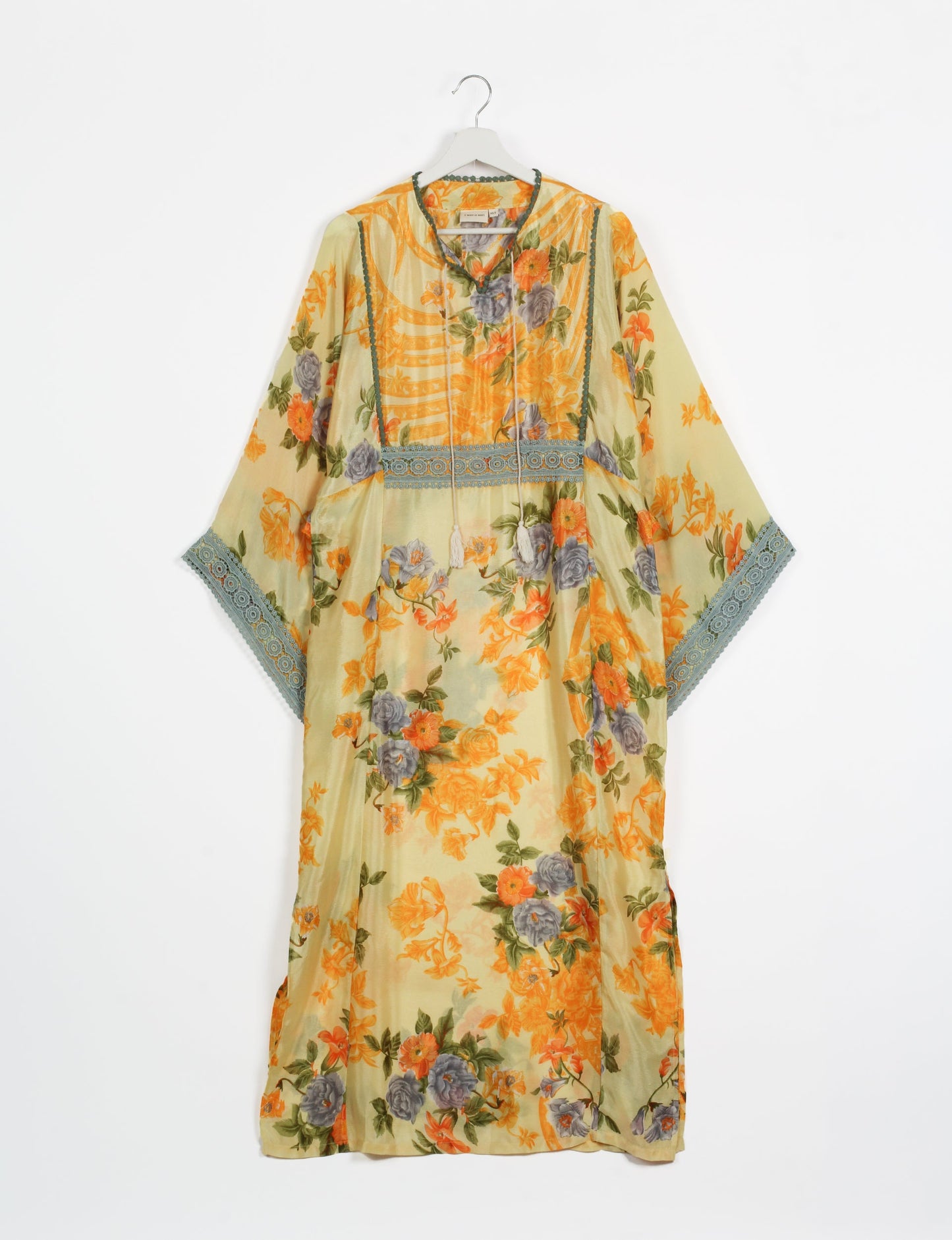 Maxi Kaftan with cotton lace on sleeves and midriff, featuring a tie-up neckline with tassels. Ankle-length, eco-friendly fashion made from recycled materials, offering sustainable women’s clothing for a chic, earth-friendly wardrobe.