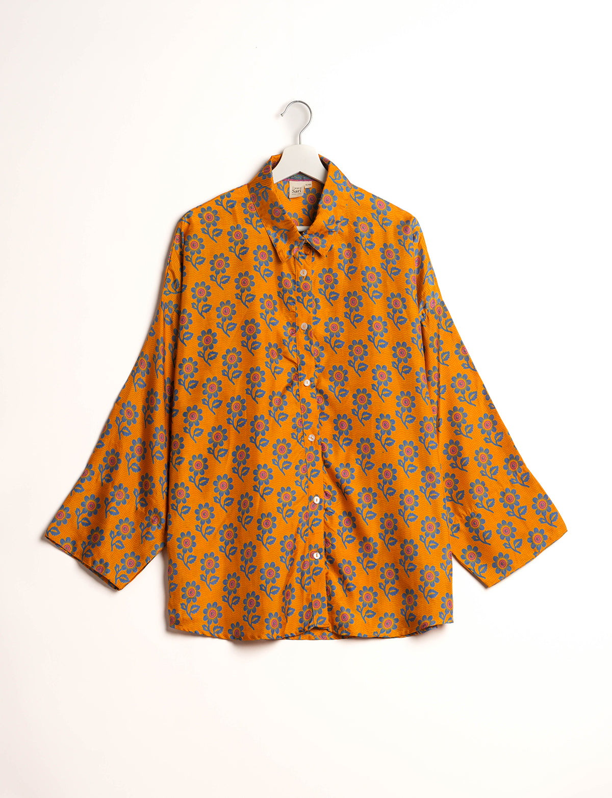 Experience chic comfort with our OVERSIZED SHIRT – a one-of-a-kind piece crafted from sari waste by talented Indian female artisans. With 3/4 length sleeves, a regular shirt collar, and a contrasting inner collar band, this shirt is perfect for work or casual hangouts. Versatile and stylish, it pairs effortlessly over a shift dress, jumpsuit, or with pants.