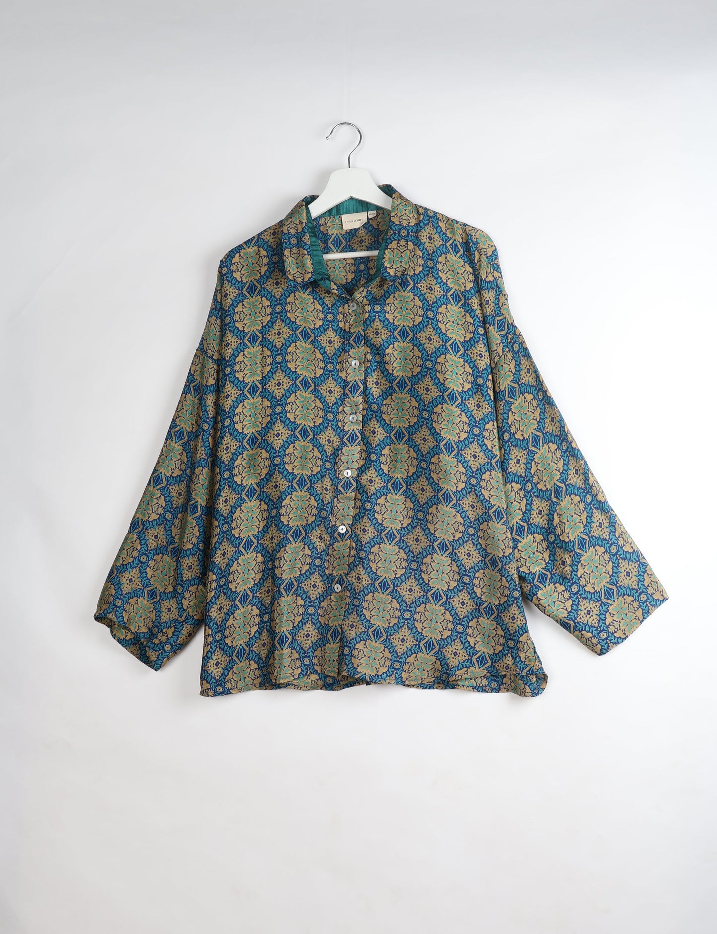 Experience chic comfort with our OVERSIZED SHIRT – a one-of-a-kind piece crafted from sari waste by talented Indian female artisans. With 3/4 length sleeves, a regular shirt collar, and a contrasting inner collar band, this shirt is perfect for work or casual hangouts. Versatile and stylish, it pairs effortlessly over a shift dress, jumpsuit, or with pants.