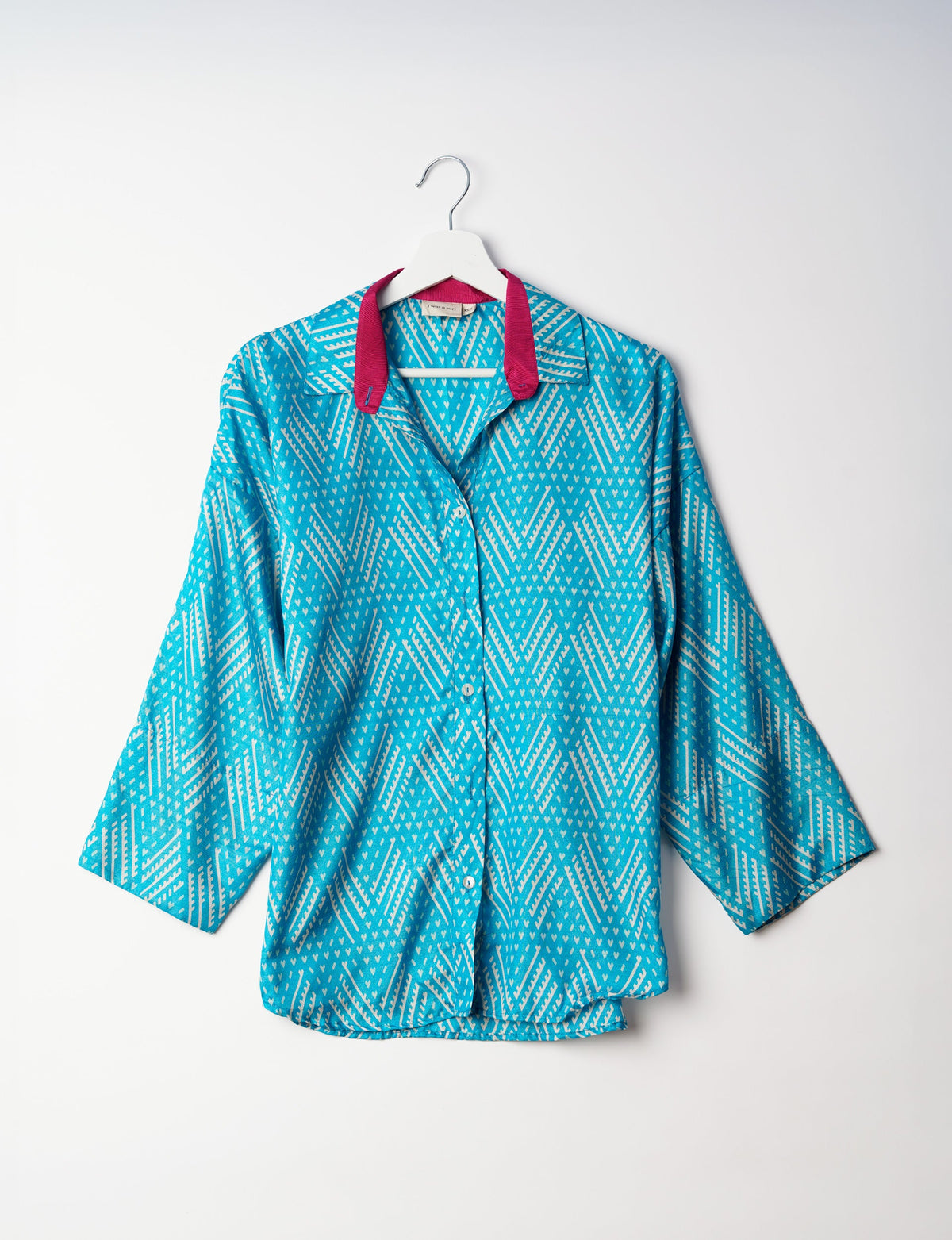 Experience chic comfort with our OVERSIZED SHIRT – a one-of-a-kind piece crafted from sari waste by talented Indian female artisans. With 3/4 length sleeves, a regular shirt collar, and a contrasting inner collar band, this shirt is perfect for work or casual hangouts. Versatile and stylish, it pairs effortlessly over a shift dress, jumpsuit, or with pants.