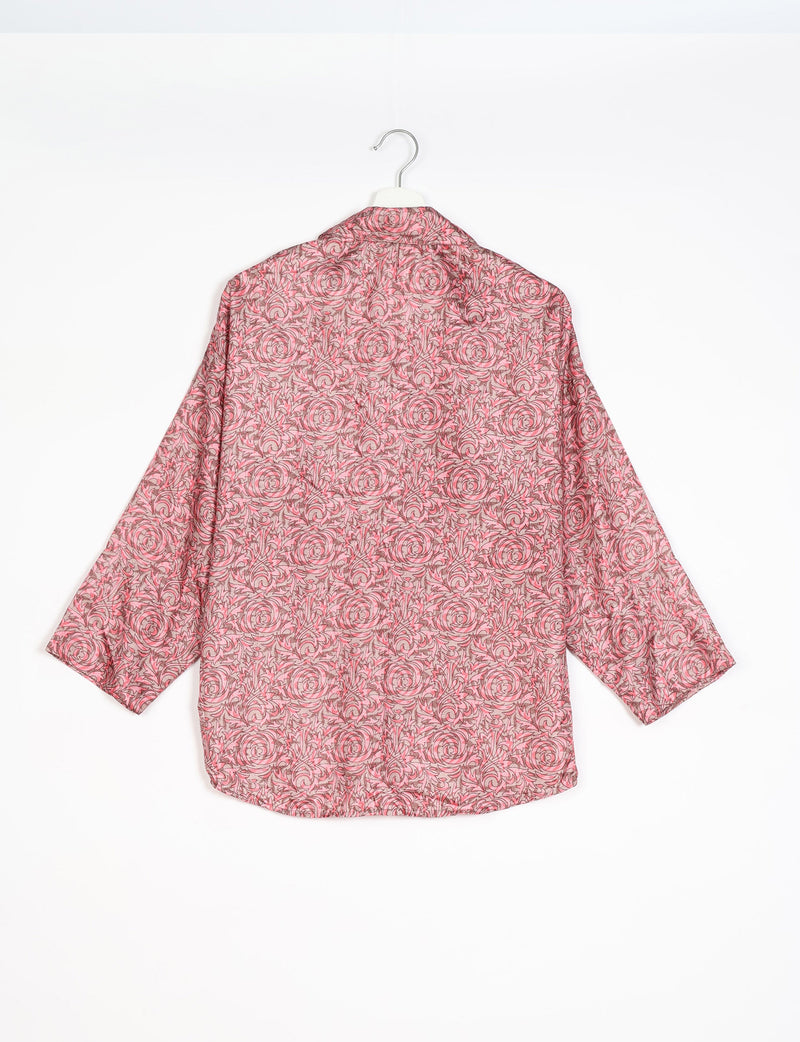 Oversized pink floral shirt with long sleeves and collar, shown from back, hanging on white hanger against white background