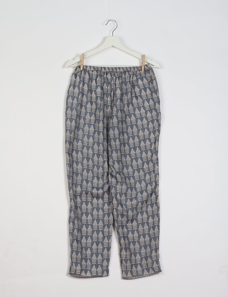 Grey pull-on pants with beige geometric pattern, elastic waistband, hanging on white hanger against white background