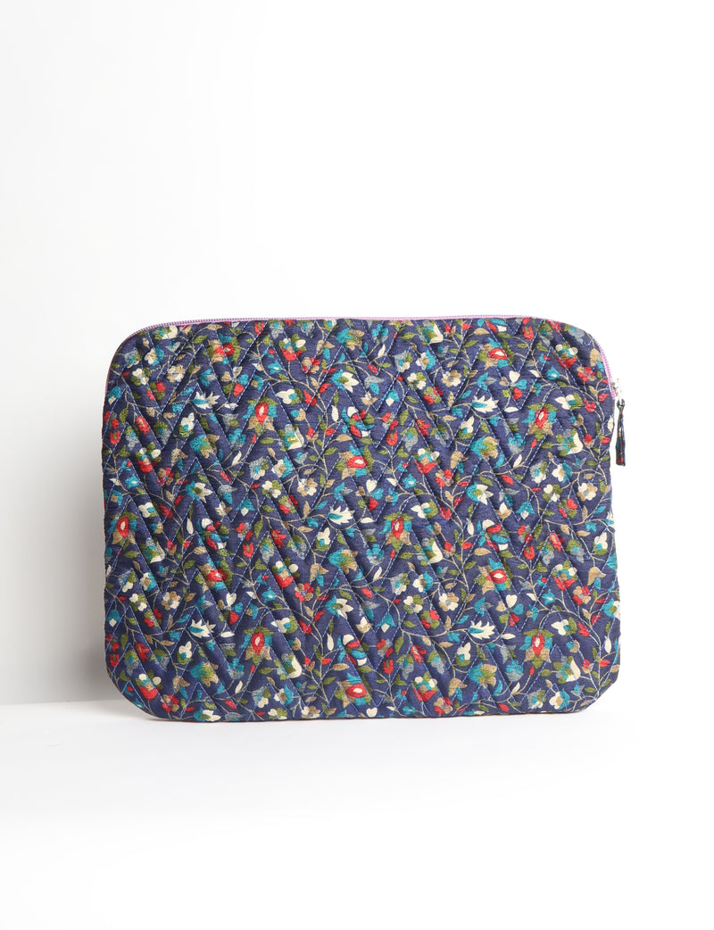 Quilted laptop sleeve with purple paisley pattern, blue zipper, and rounded corners, shown flat on white background