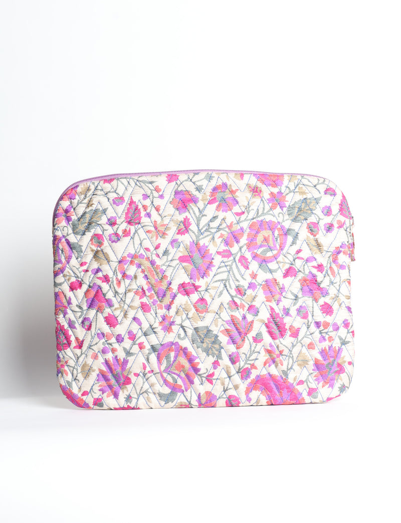 Quilted laptop sleeve with purple paisley pattern, blue zipper, and rounded corners, shown flat on white background