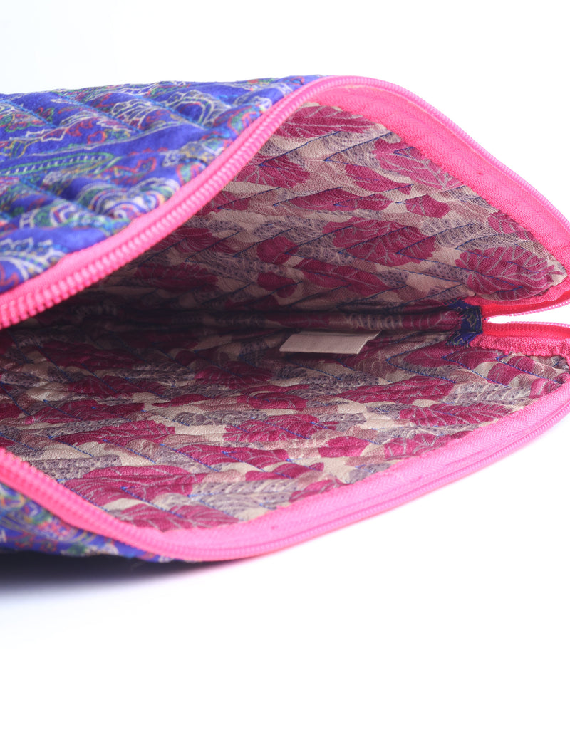 Quilted laptop sleeve with purple paisley exterior, red patterned interior, and light blue zipper, partially open showing label