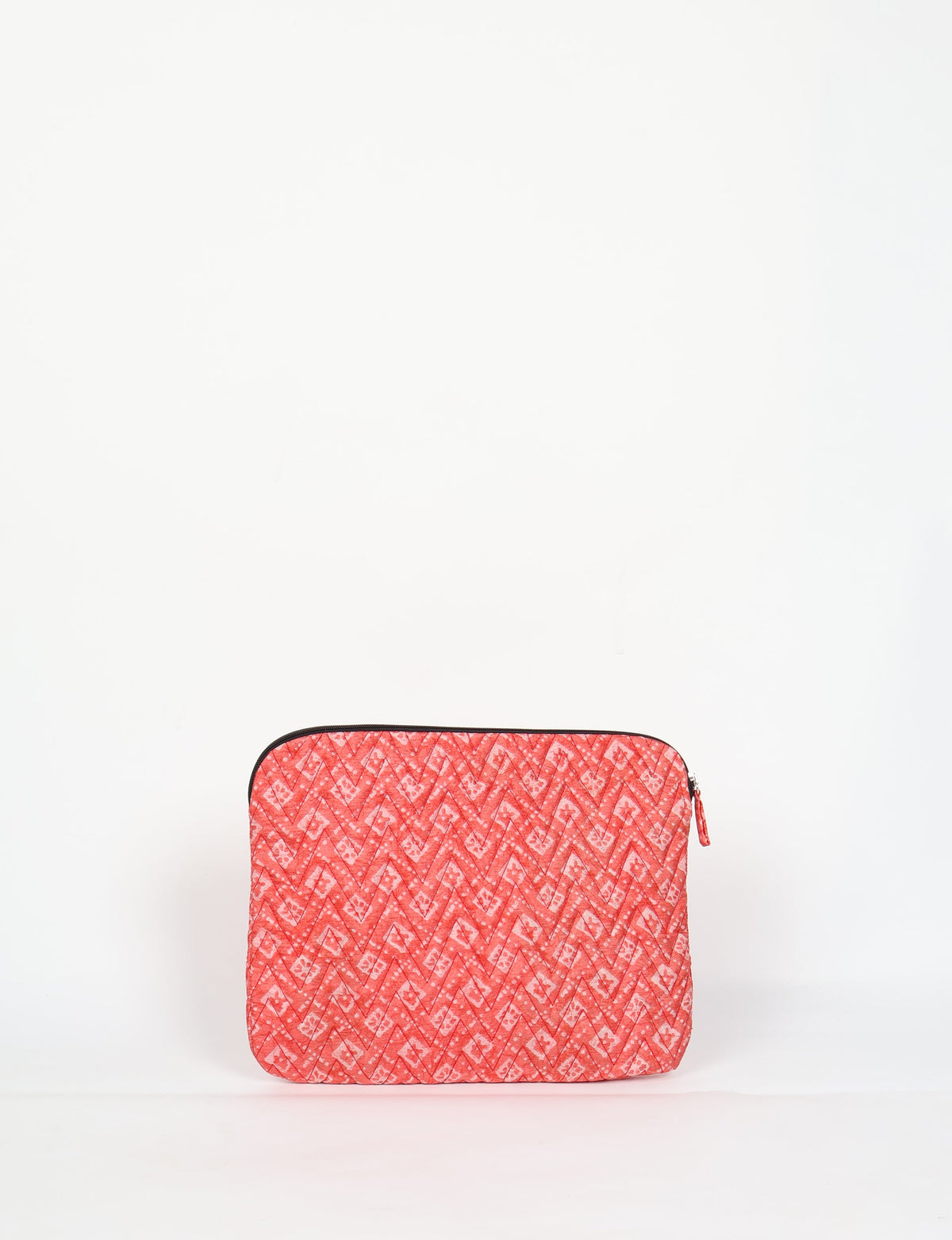 Quilted laptop sleeve in pink with geometric chevron and floral pattern, front view, zipper closure on top edge