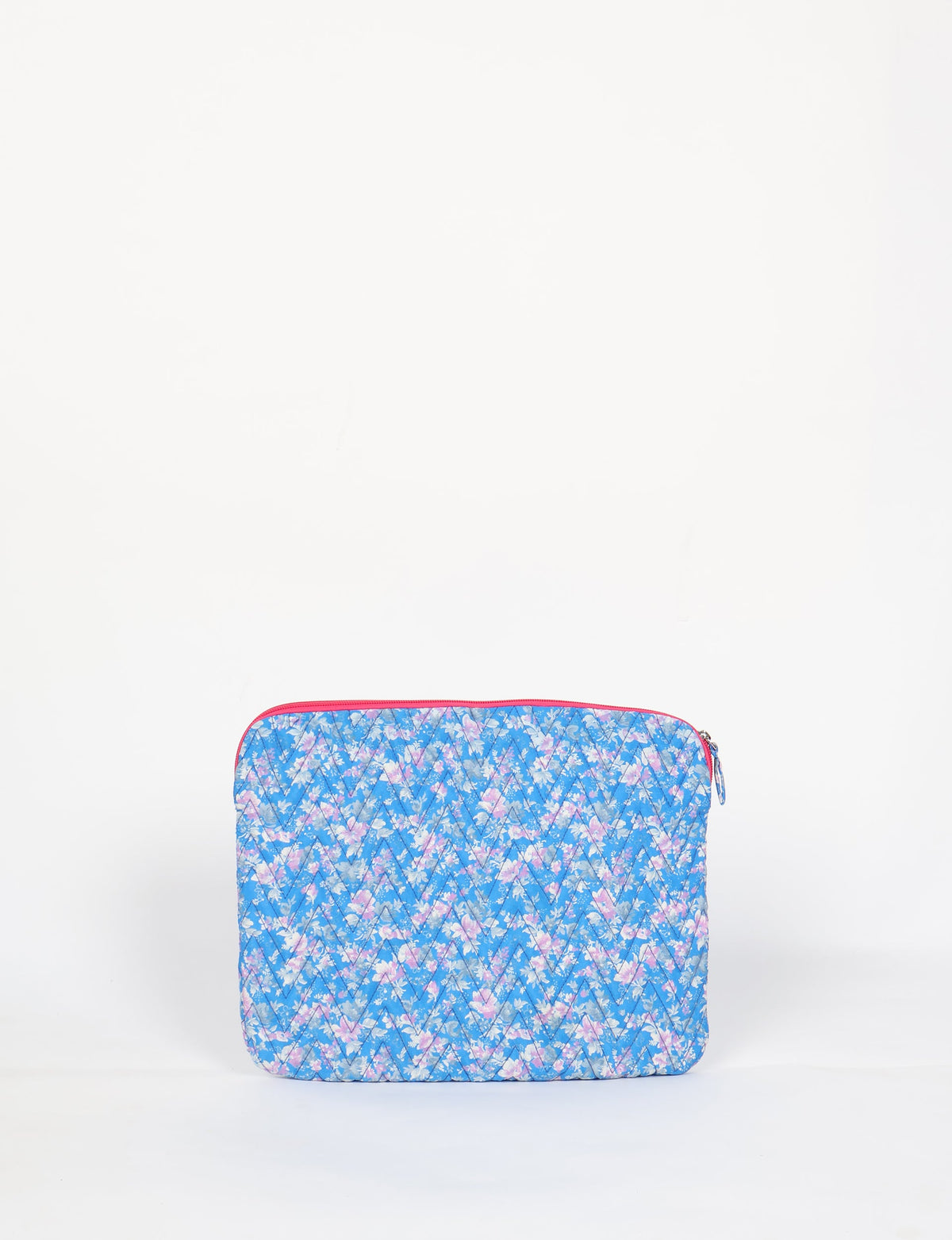Quilted laptop sleeve with blue floral pattern, pink zipper, and diagonal stitching, shown front view on white background