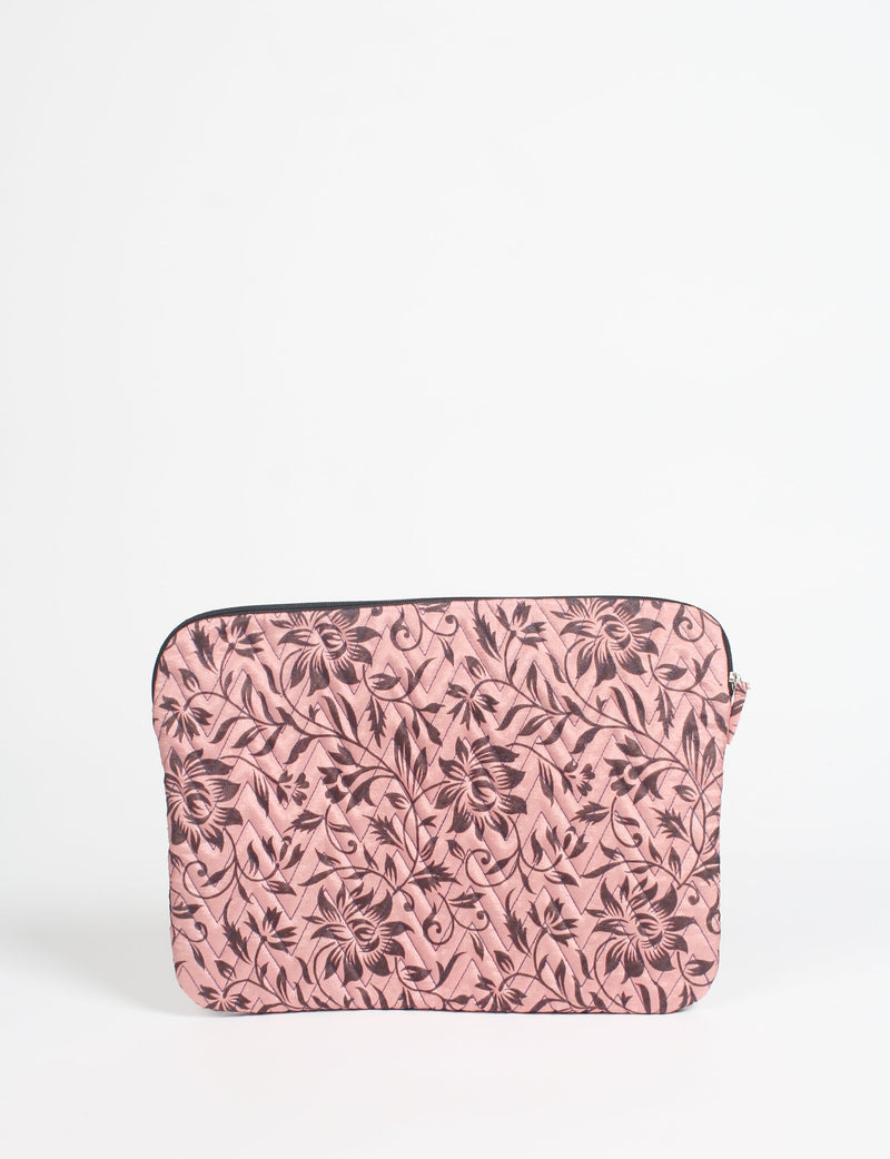 Quilted laptop sleeve in pink with dark floral pattern, front view, zipper closure, flat on white background