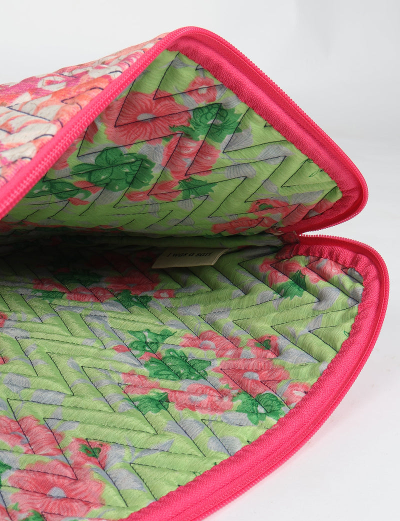 Quilted laptop sleeve with pink floral exterior and green floral interior, visible zipper, and chevron stitching pattern