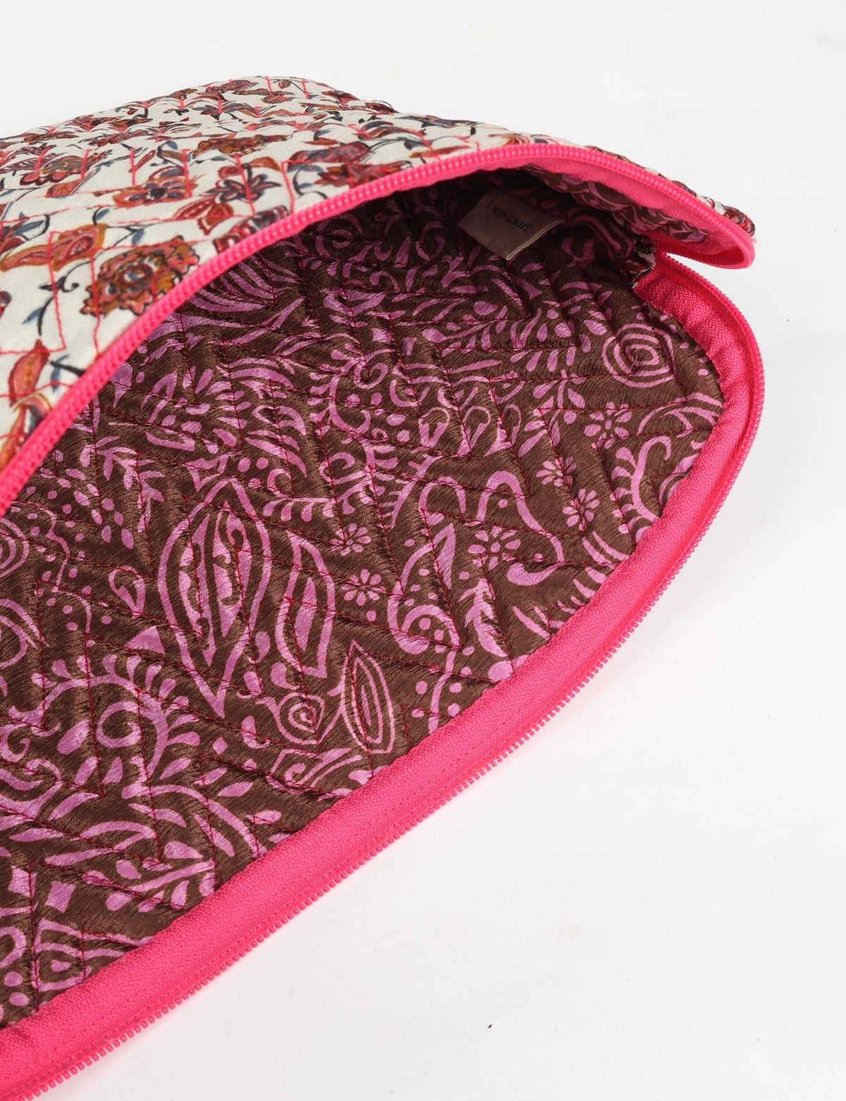 Quilted laptop sleeve with beige floral exterior, pink zipper, and brown interior with pink paisley pattern, open view