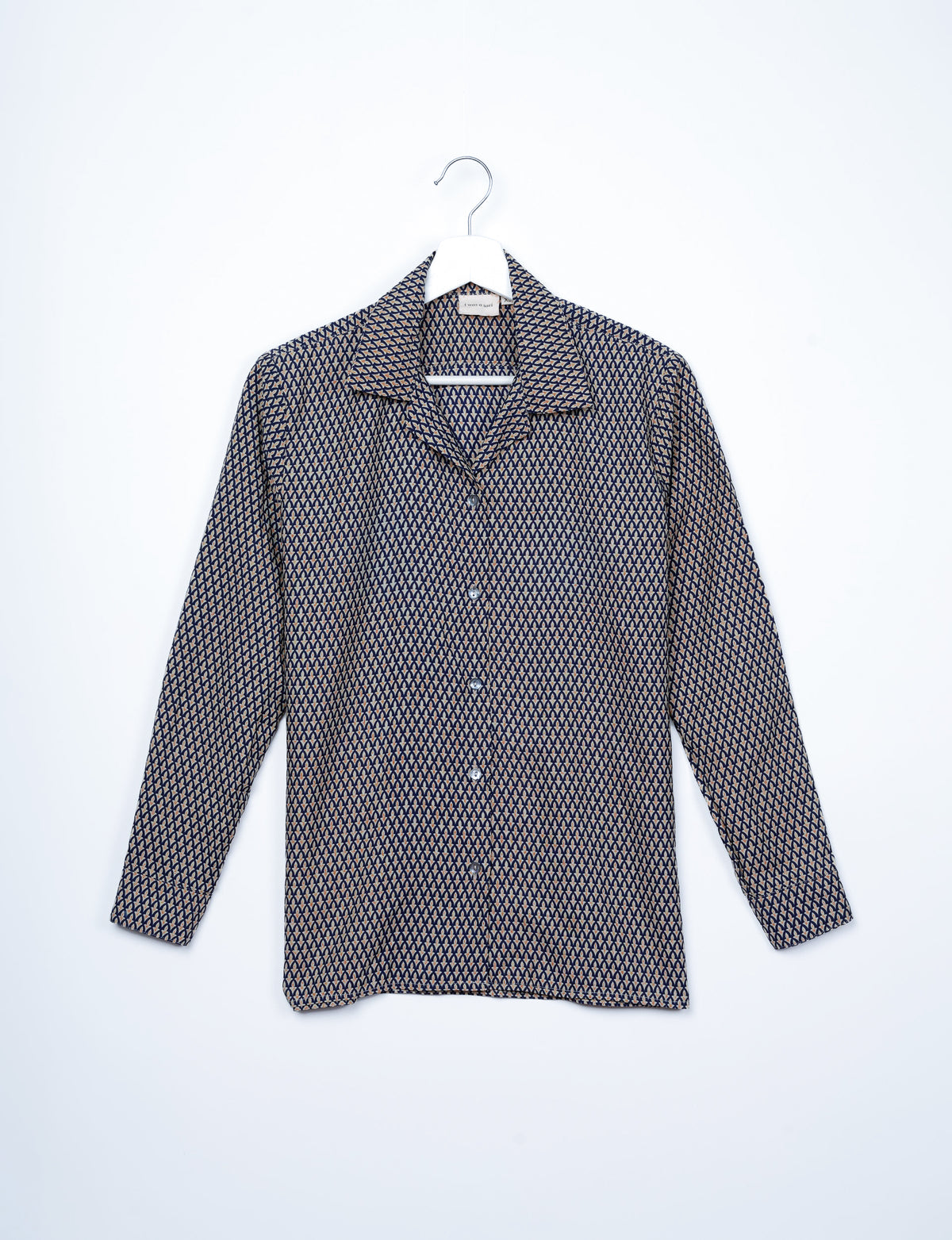 Long-sleeve button-up resort shirt with black and beige micro geometric pattern, displayed on white hanger, front view