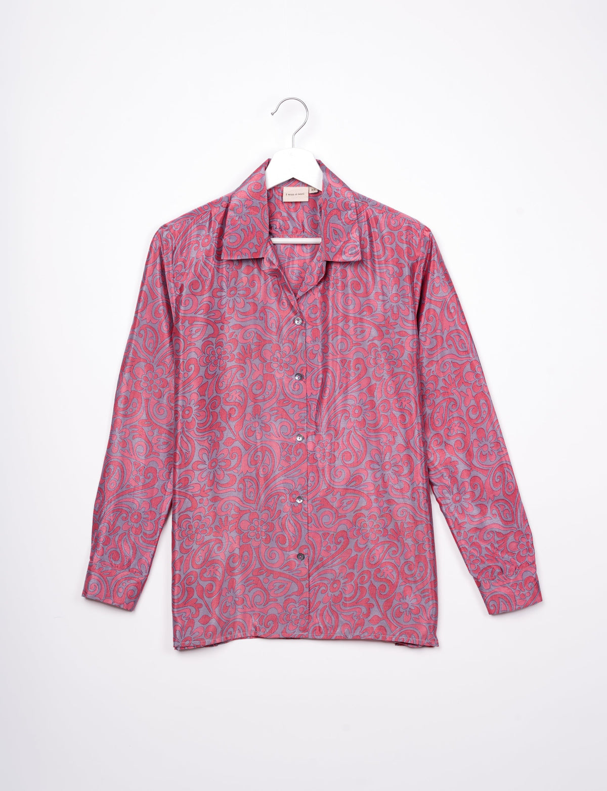 Long-sleeve pink floral resort shirt with button front and spread collar hanging on white hanger against white background