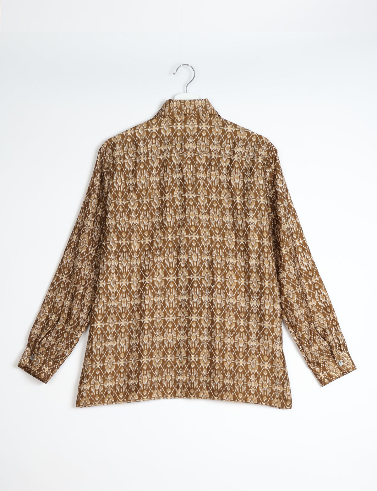Beige and brown Indian ethnic patterned long-sleeve resort shirt shown from back on white hanger against white background