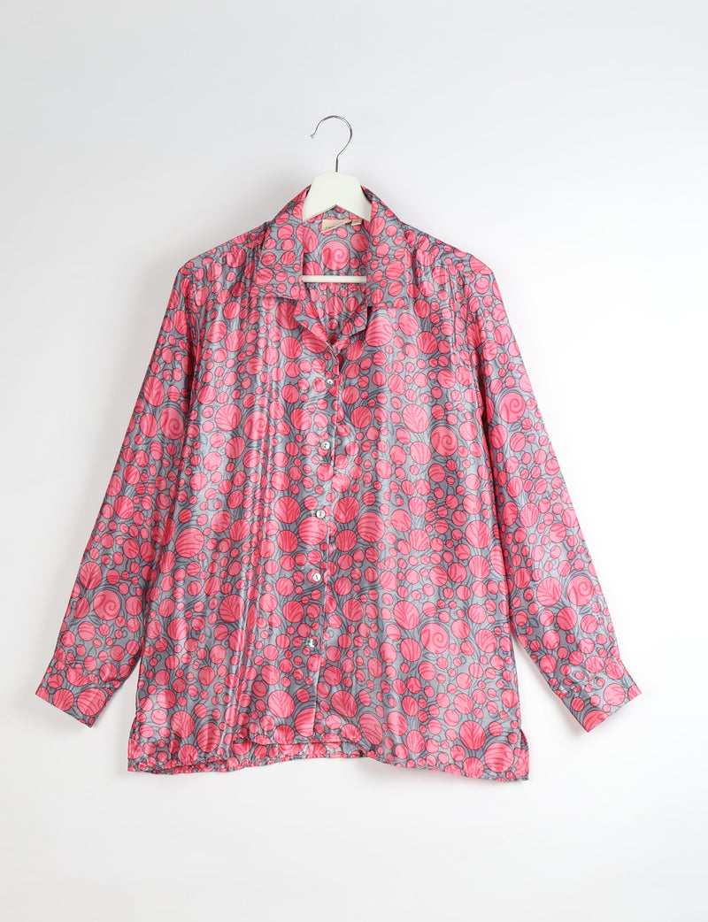 Long-sleeve button-up resort shirt with pink circular leaf pattern on gray fabric, hanging on white hanger, front view