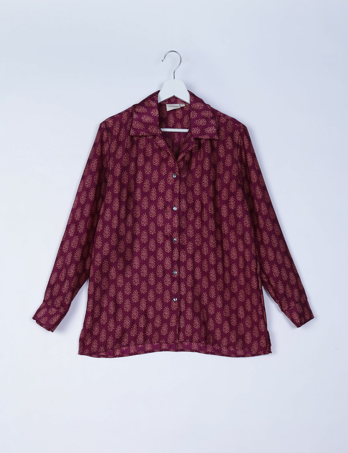 Red long-sleeve resort shirt with beige micro leaf pattern, button front, spread collar, hanging on white hanger, front view