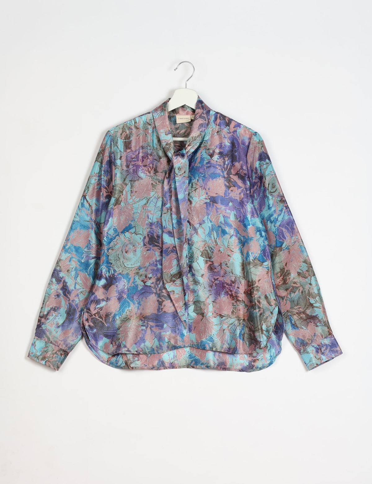 Long-sleeve blue abstract floral bowtie shirt hanging on white hanger against white background