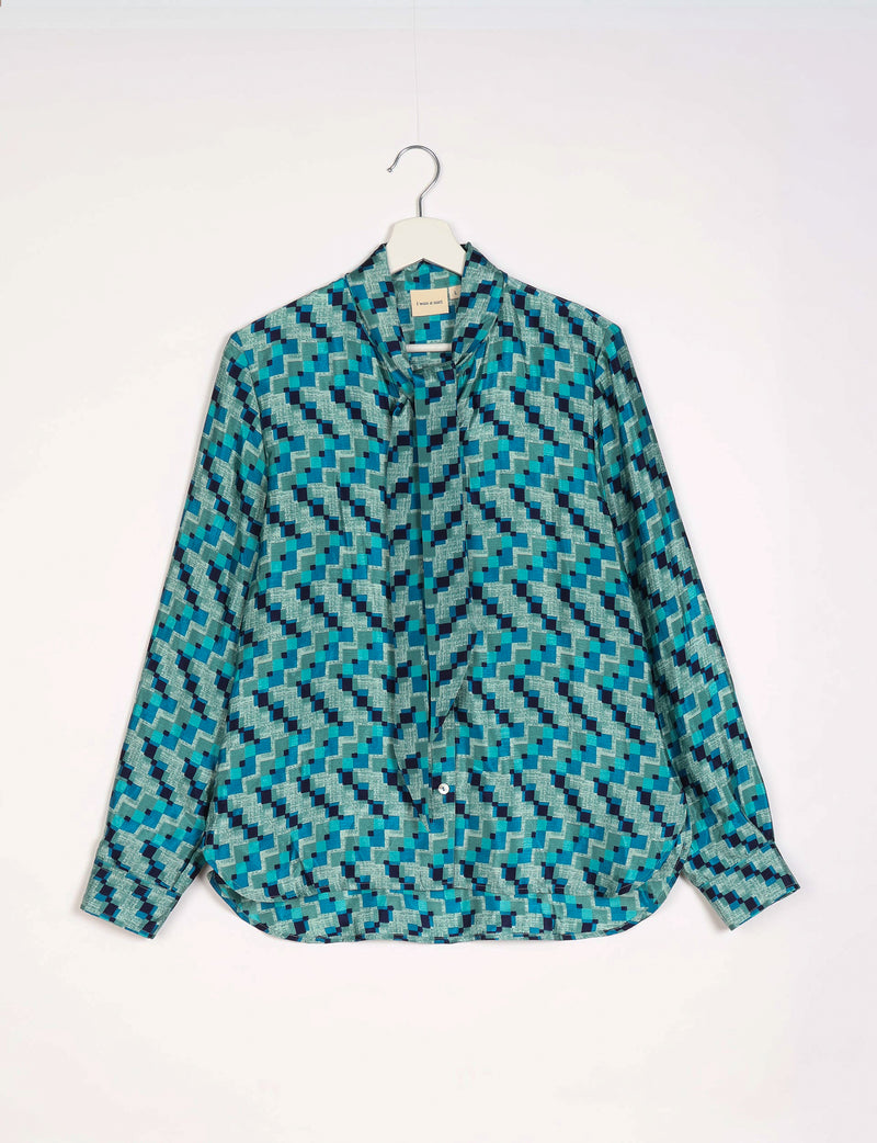 Blue geometric patterned long-sleeve shirt with bowtie collar, button front, and cuffed sleeves hanging on white hanger