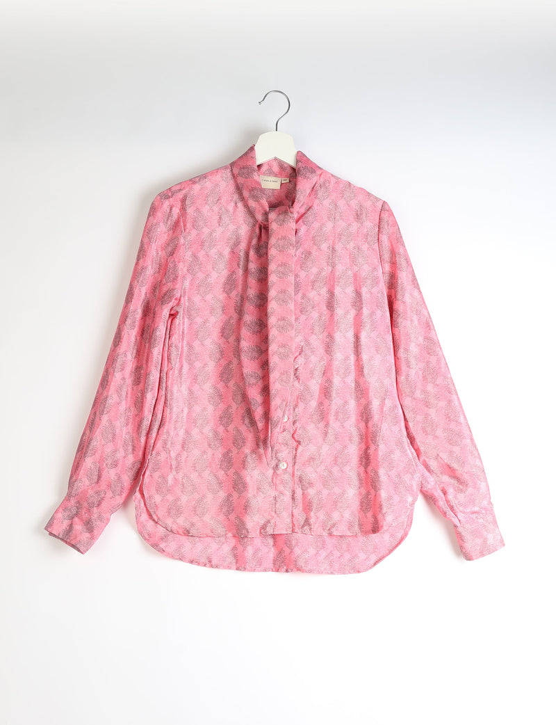 Pink long-sleeve button-up shirt with bowtie collar and gray leaf pattern, hanging on white hanger against white background