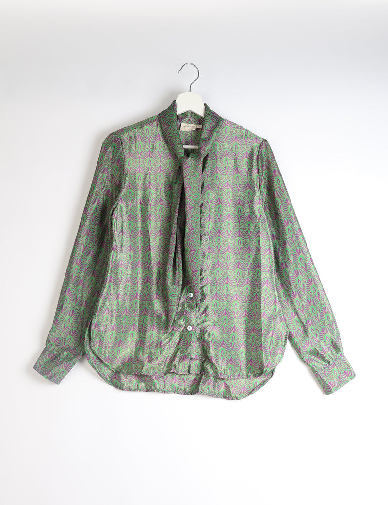 Green and purple patterned long-sleeve button-up shirt with bowtie collar hanging on white hanger against white background