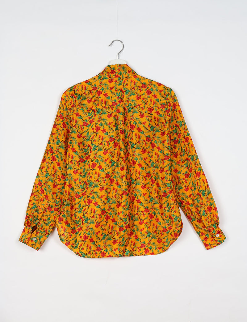 Yellow long-sleeve shirt with red and green tropical floral print, shown from back on white hanger against white background