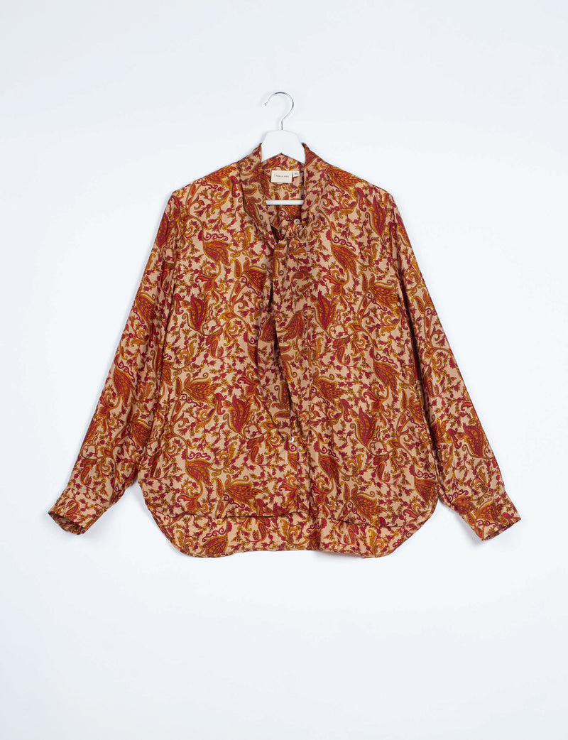 Long-sleeve button-up shirt with orange and red abstract floral paisley pattern, bowtie neckline, hanging on white hanger