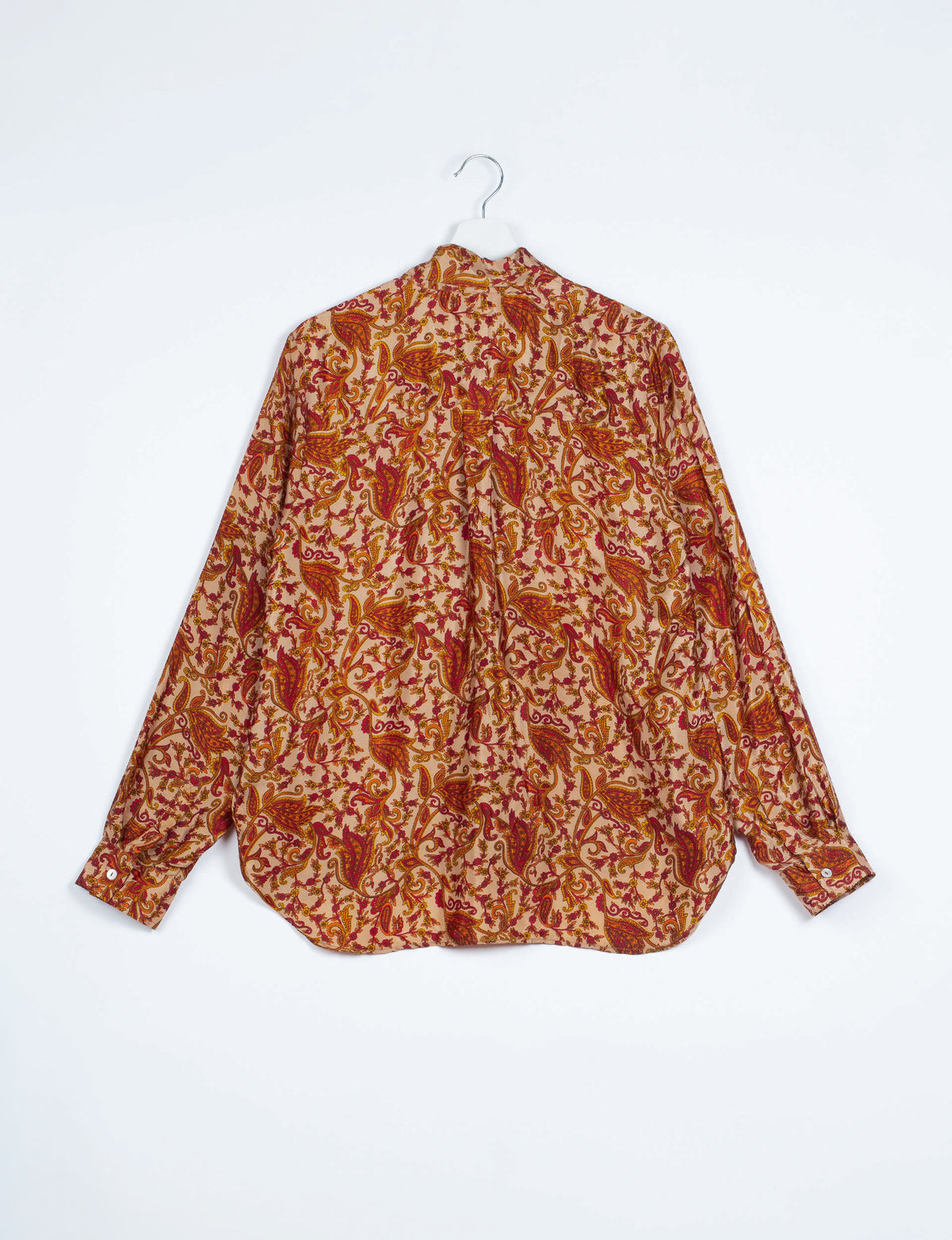 Long-sleeve shirt with orange and red abstract floral paisley pattern, shown from back on white hanger against white background