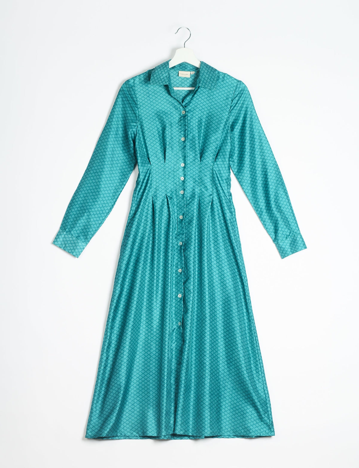 Blue midi shirt dress with micro diamond pattern, long sleeves, button front, and pointed collar hanging on white hanger