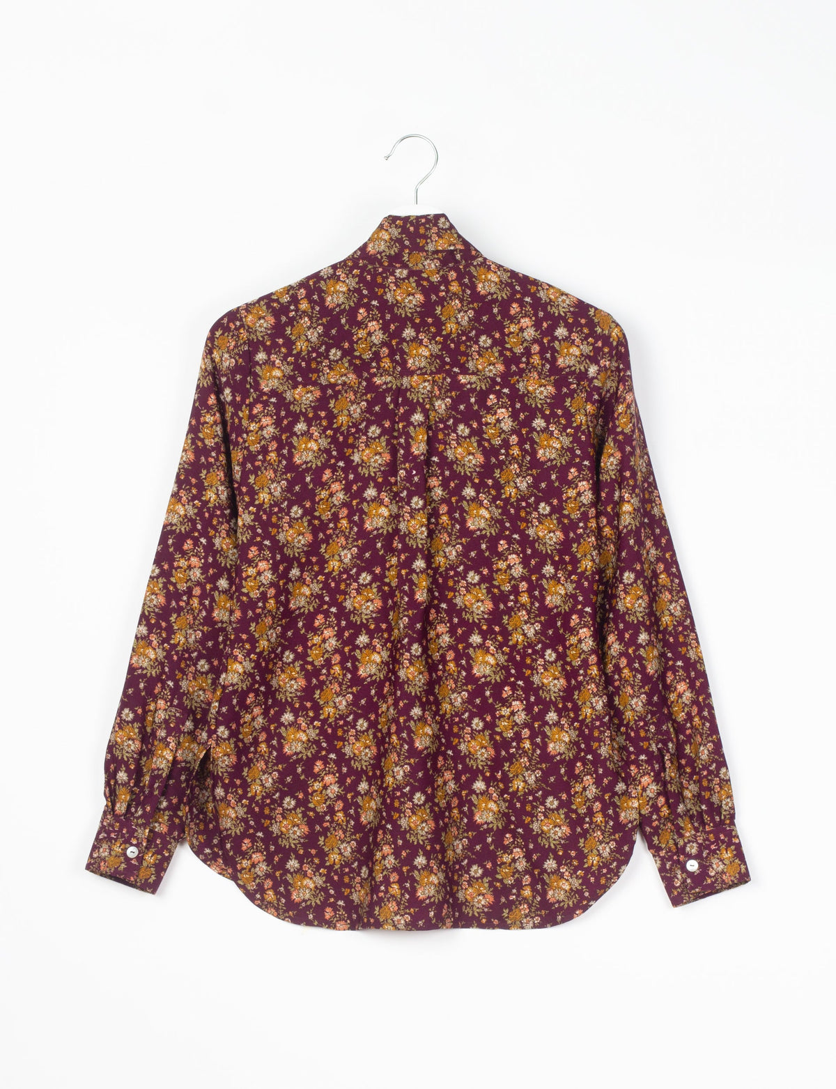 Red floral long-sleeve shirt with button cuffs hanging on a metal hanger, back view, small orange and white flowers pattern