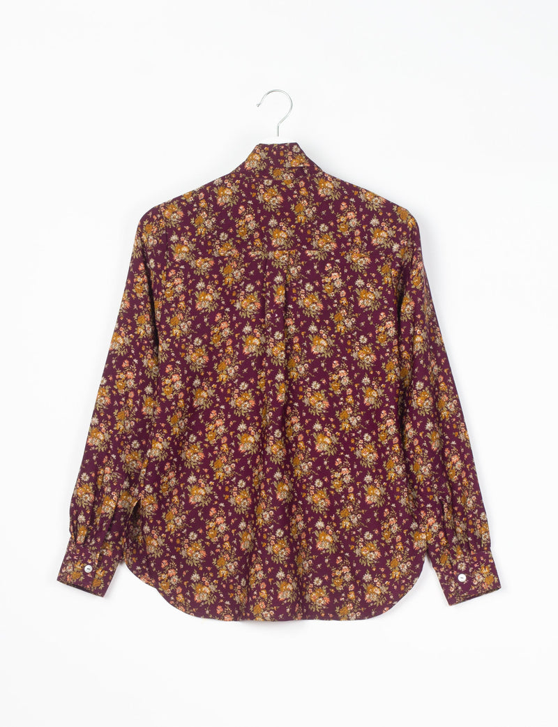 Red floral long-sleeve shirt with button cuffs hanging on a metal hanger, back view, small orange and white flowers pattern