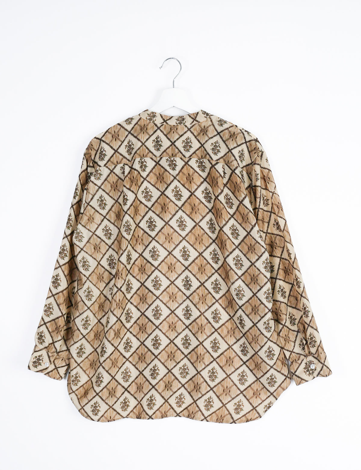 Beige longline shirt with brown geometric diamond and floral pattern, long sleeves, buttoned cuffs, shown from back on hanger